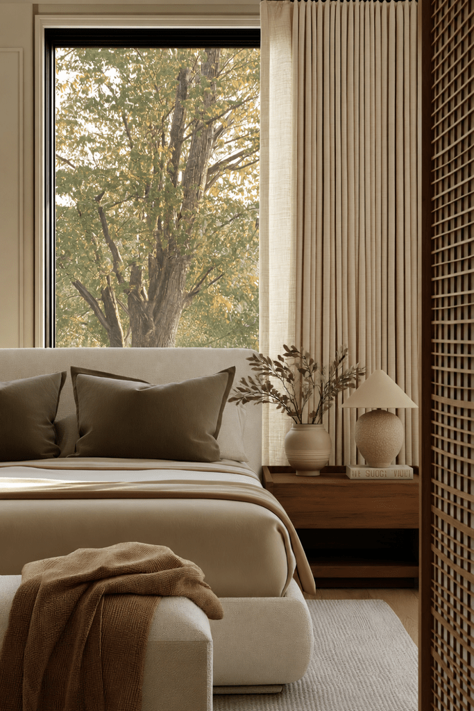 Neutral bedroom with olive pillows, walnut nightstand, ceramic lamp, leafy branches, linen curtains, and warm autumn textiles.