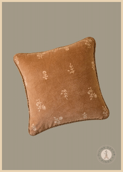Magnolia Marjorie square velvet pillow in warm rust with delicate cream floral embroidery and contrasting piping.