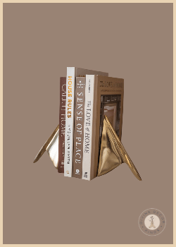 Gold Lincoln Bookends from Shoppe at The Avenue holding neutral design books on a rustic wood shelf.