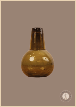 Green recycled glass Norway Carafe from Shoppe at The Avenue with coordinating drinking glass in a rounded amber-green design.